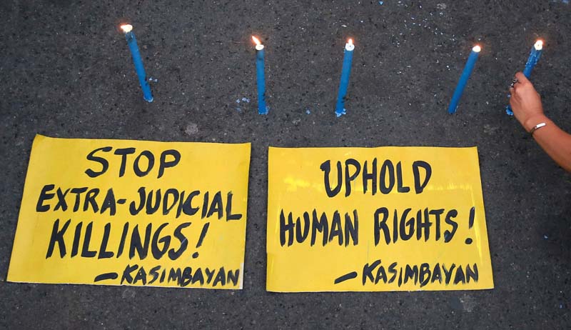 File- A human rights advocates offers prayers and lights candles during a call for justice for the numerous extrajudicial killings, which have increased since President Rodrigo Duterte, took office at the Redemptorist church in Paranaque city, metro Manila, Philippines, on August 10, 2016. Photo: Reuters