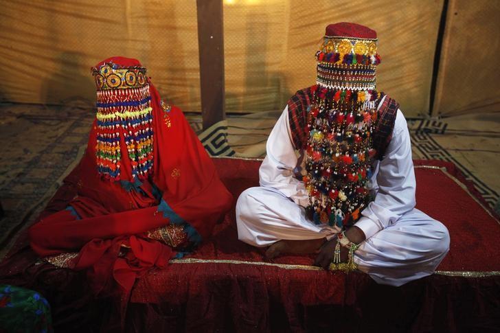 A bride and groom sit together during a mass marriage ceremony held in Karachi January 2, 2015. REUTERS/Athar Hussain/Files