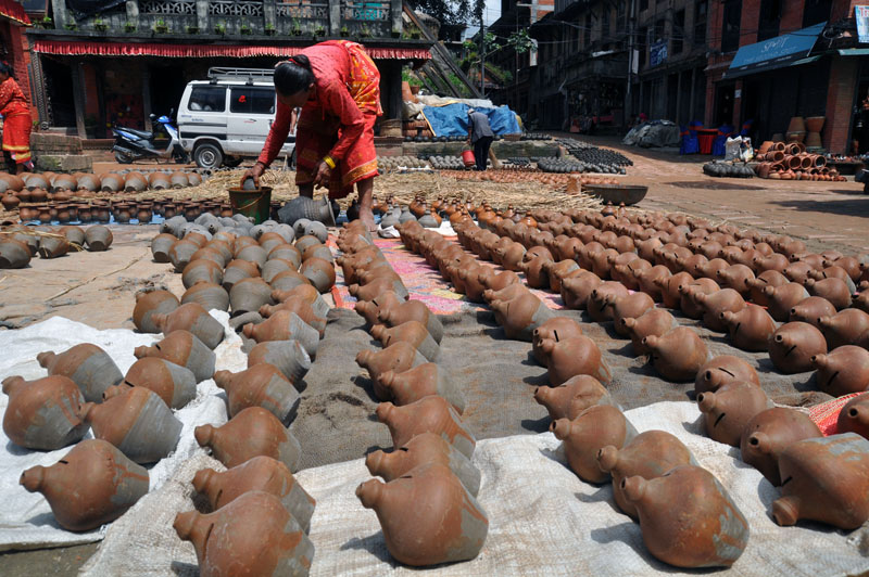 A woman is seen colouring piggy banks and other clay pots at a famous potters' locality, Taalko, in Bhaktapur district on Saturday, September 10, 2016. Piggy banks made in Bhaktapur have good markets in the surrounding districts including Lalitpur, Kathmandu and Kavrepalanchok. Photo: RSS