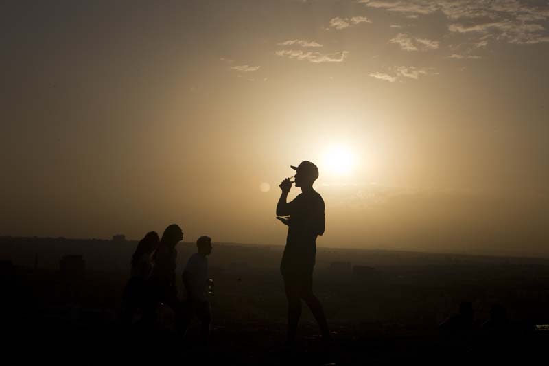 File- A youth takes a drink on a hill overlooking the city after a long hot day in Madrid, Spain, on September 6, 2016. Photo: AP