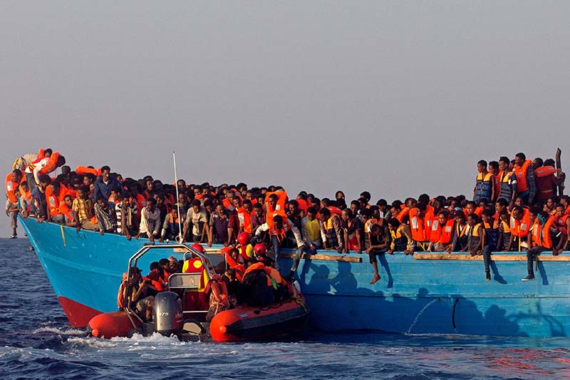 A rescue boat of the Spanish NGO Proactiva approaches an overcrowded wooden vessel with migrants from Eritrea, off the Libyan coast in Mediterranean Sea, on August 29, 2016. Photo: Reuters