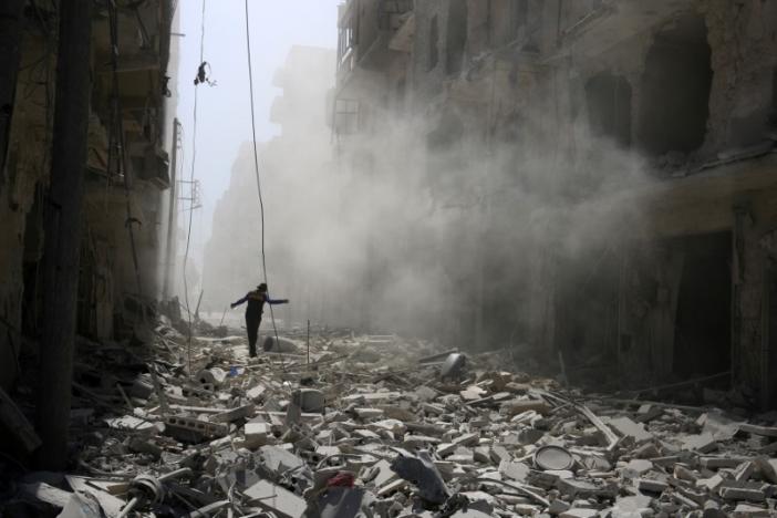 A man walks on the rubble of damaged buildings after an airstrike on the rebel held al-Qaterji neighborhood of Aleppo, Syria September 25, 2016. REUTERS/Abdalrhman Ismail