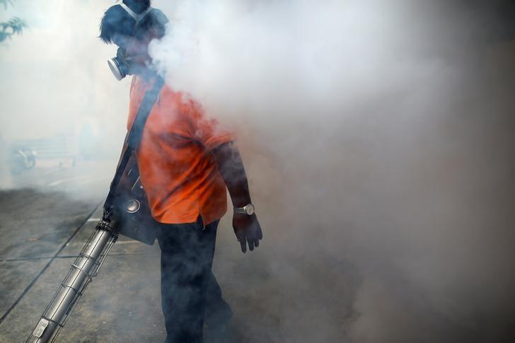 A city worker fumigates the area to control the spread of mosquitoes at a university in Bangkok, Thailand, September 13, 2016. REUTERS/Athit Perawongmetha