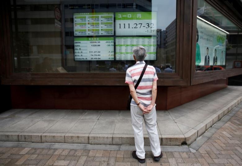 A man looks at an electronic board showing the Japanese yen's exchange rate against Euro outside a brokerage in Tokyo, Japan, July 6, 2016. REUTERS/Issei Kato