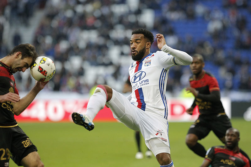Lyon's Alexandre Lacazette (center) challenges for the ball with Guingamp's Christophe Kerbrat, left, during their French League One soccer match in Decines, near Lyon, central France, on Saturday, October 22, 2016. Photo: AP