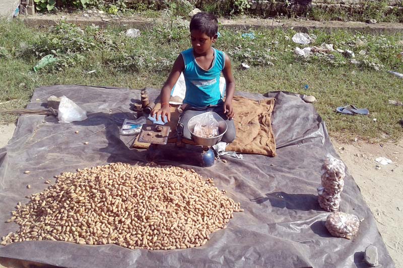 A 10-year-old child sells peanuts on a roadside in Gulariya, the Bardiya district headquarters, on Thursday, October 20, 2016. The child says he does not go to school, but earns the living for his family. Photo: RSS