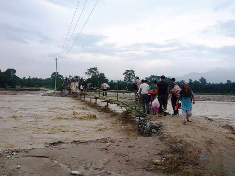Locals crossing a makeshift bridge built over the Tangting Khola in Birtamod of Jhapa district on October 18, 2016. Photo: RSS