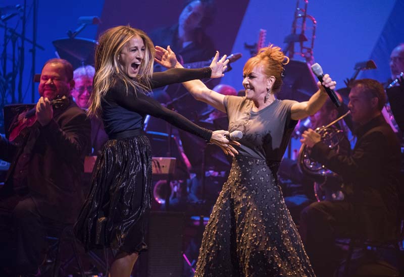 Actress Sarah Jessica Parker (L) embraces singer and actress Andrea McArdle as they perform together during a benefit concert for the Hillary Victory Fund, in New York, on Monday, October 17, 2016. Photo: AP