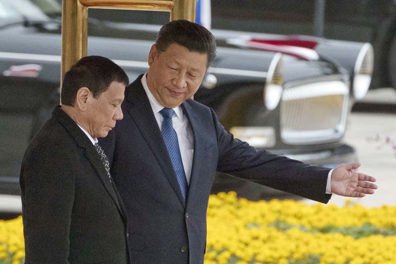 Chinese President Xi Jinping (R) shows the way to Philippine President Rodrigo Duterte during a welcome ceremony outside the Great Hall of the People in Beijing, on Thursday, October 20, 2016. Photo: AP