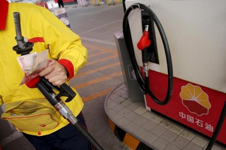 A gas station attendant pumps fuel into a customer's car at PetroChina's petrol station in Beijing, China, March 21, 2016.     REUTERS/Kim Kyung-Hoon/File Photo