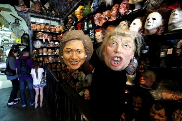 An employee holds up masks depicting Democratic presidential nominee Hillary Clinton and Republican presidential nominee Donald Trump at Hollywood Toys &amp; Costumes in Los Angeles, California U.S., October 26, 2016.   REUTERS/Mario Anzuoni