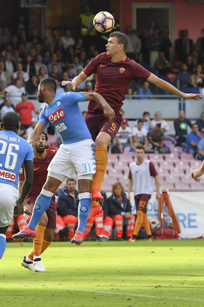 Roma's Edin Dzeko (right) heads the ball past Napoli's Faouzi Ghoulam during a Serie A soccer match between Napoli and Roma at the San Paolo stadium in Naples, Italy, Saturday, Oct. 15, 2016. (Ciro Fusco /ANSA via AP)