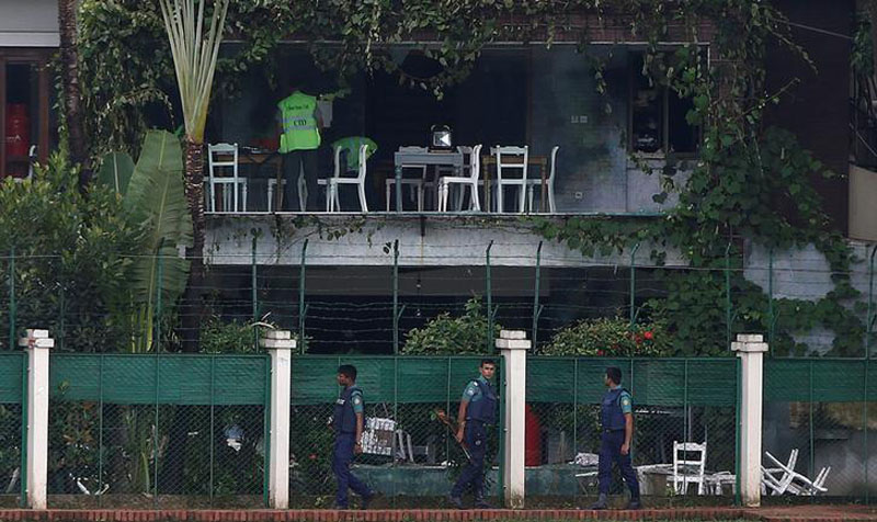 Policemen patrol outside the Holey Artisan Bakery and the O'Kitchen Restaurant as others inspect the site after gunmen attacked, in Dhaka, Bangladesh, on July 3, 2016. Photo: Reuters