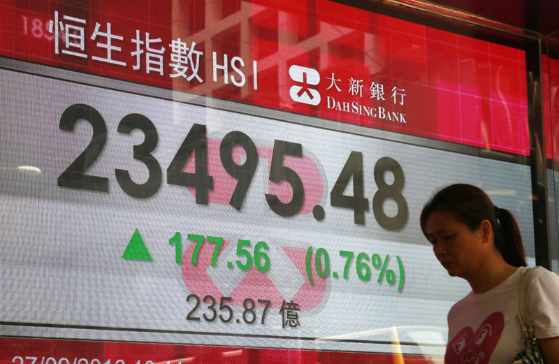 A woman walks past a display of the Hang Seng Index at a bank in Hong Kong on Tuesday, September 27, 2016.  Photo: AP