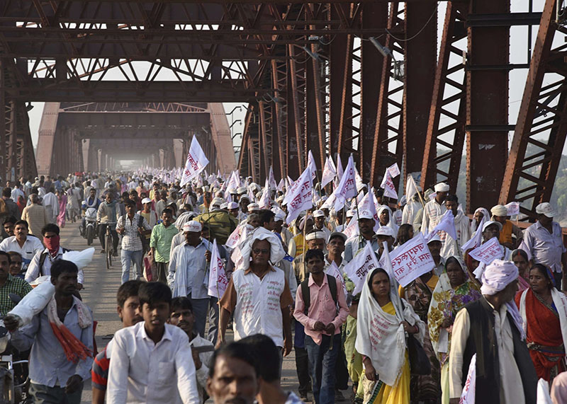 Hindu pilgrims hold religious flags and walk on a crowded bridge after a stampede on the same bridge on the outskirts of Varanasi, India, on Saturday, October 15, 2016. Photo: AP