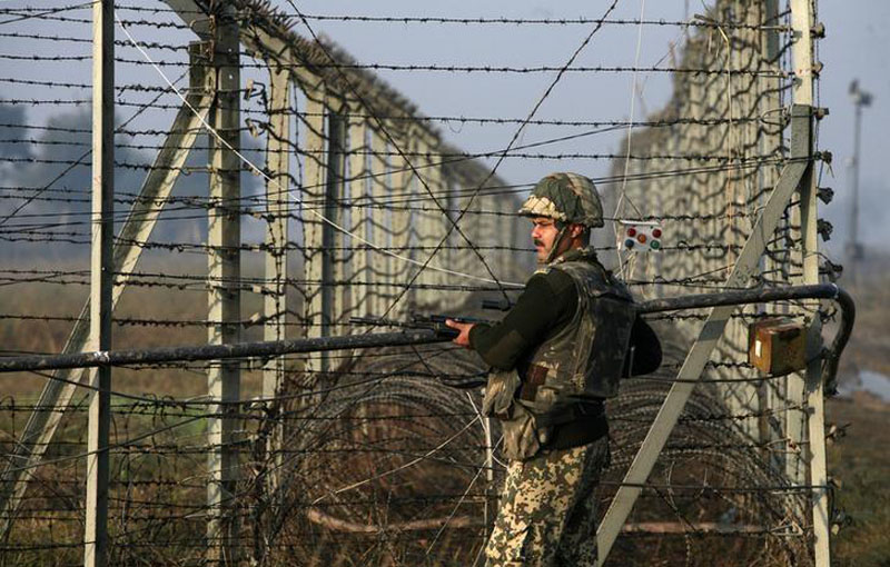 An Indian Border Security Force (BSF) soldier patrols near the fenced border with Pakistan in Suchetgarh, southwest of Jammu, on January 11, 2013. Photo: Reuters