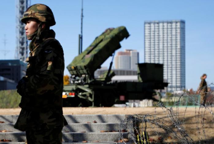 Members of the Japan Self-Defence Forces stand guard near Patriot Advanced Capability-3 (PAC-3) land-to-air missiles, deployed at the Defense Ministry in Tokyo, Japan, December 7, 2012. REUTERS/Issei Kato/File Photo