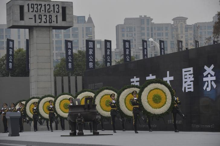 Paramilitary policemen carry wreaths as they march during a ceremony mark the second national memorial day for the Nanjing Massacre, at the Nanjing Massacre Museum in Nanjing, Jiangsu province, China, December 13, 2015.   REUTERS/China Daily /File Photo