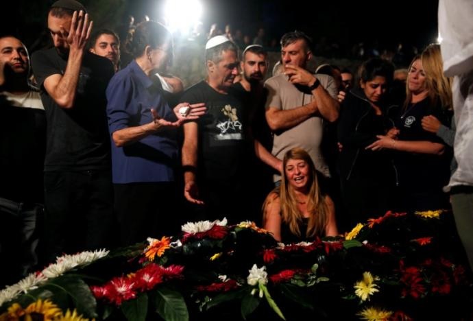 Relatives and friends mourn over the grave of Israeli policeman Yosef Kirma who was kissled by a Palestinian assailant who fired from a car before being shot dead by Israeli police in Jerusalem, at Mount Herzl cemetery in Jerusalem on October 9, 2016. Photo: Reuters