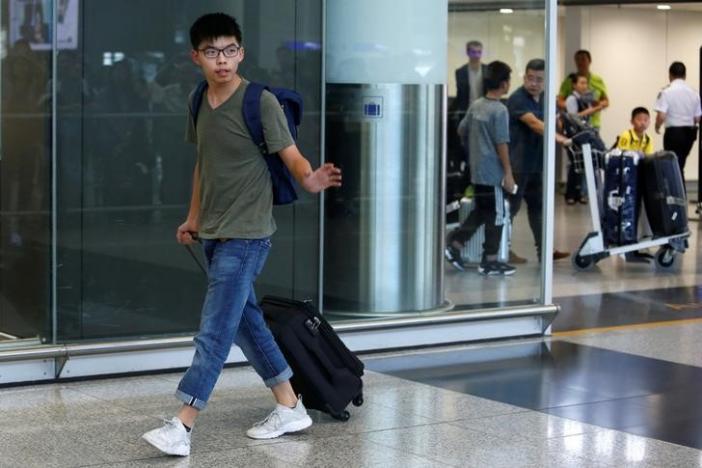 Pro-democracy activist Joshua Wong acknowledges journalists upon his arrival at Hong Kong Airport in Hong Kong, China October 5, 2016, after being deported from Bangkok.      REUTERS/Bobby Yip