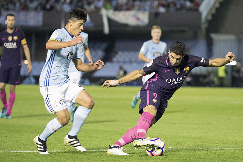 Barcelona's Luis Suarez (right) challenges for the ball with Celta's  Roncaglia, during the Spanish La Liga soccer match between Celta Vigo and FC Barcelona at the Balaidos stadium in Vigo, Spain, on Sunday, October 2, 2016. Photo: AP
