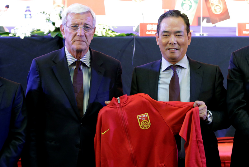 Marcello Lippi (L) and Cai Zhenhua, president of the Chinese Football Association (CFA), pose for a photo as Marcello Lippi is given China's national team coach shirt at a news conference in Beijing, China October 28, 2016. Photo: Reuters