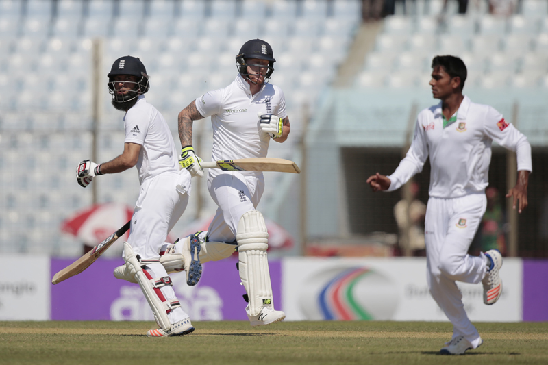 England's Moeen Ali, left, and Ben Stokes, center, run between the wickets, as Bangladesh's Mehedi Hasan Miraz, right, runs to stop the ball, on the first day of their first cricket test match in Chittagong, Bangladesh, Thursday, Oct. 20, 2016. Photo: AP