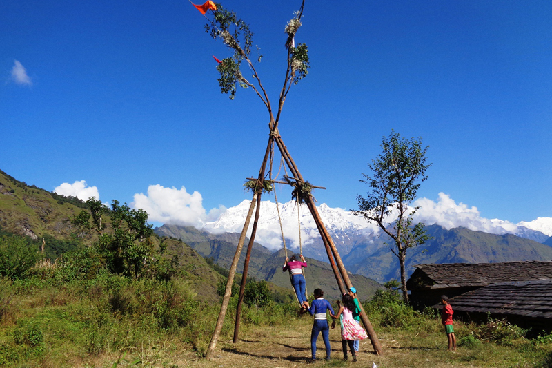 Children play a swing in Kapahaldanda, Takam-9 of Myagdi district, on Wednesday, October 12, 2016. Seen in the background is a beautiful mountain range. Such swings are popular among Nepali children during the Dashain festival. Photo: RSS