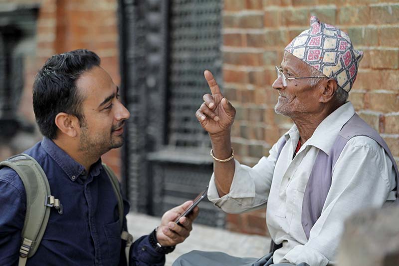 Nepali photographer Jay Poudyal chats with an elderly man in Kathmandu, on Monday, October 17, 2016. Photo: AP