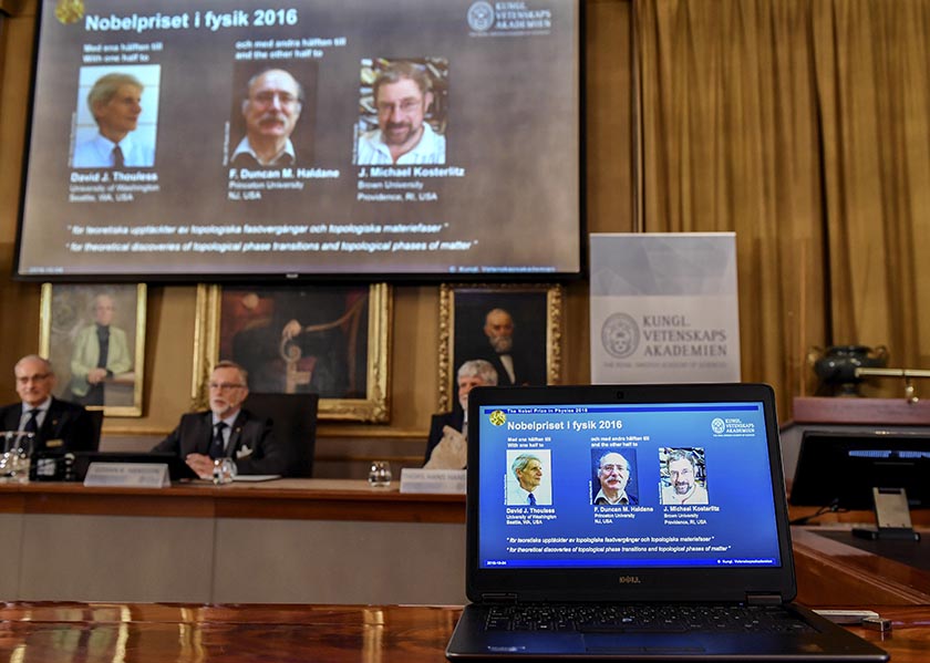 The Royal Academy of Sciences members, from left, Professor Nils Martensson, Professor Goran K Hansson and Professor Thomas Hans Hansson  reveal the winners of the Nobel Prize in physics, at the Royal Swedish Academy of Sciences, in Stockholm, Sweden, Tuesday, Oct. 4, 2016. David Thouless, Duncan Haldane and Michael Kosterlitz have won the Nobel physics prize. Nobel jury praises physics winners for 'discoveries of topological phase transitions and topological phases of matter'. (Anders Wiklund /TT via AP)