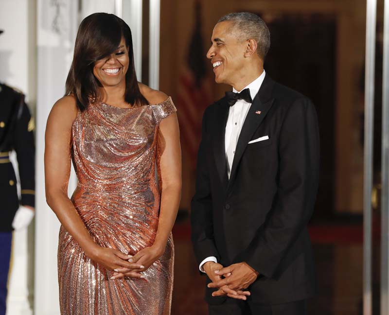 President Barack Obama and first lady Michelle Obama smile together as they wait to greet Italian Prime Minister Matteo Renzi and his wife Agnese Landini on the North Portico for a State Dinner at the White House in Washington, onTuesday, October 18, 2016. Photo: AP
