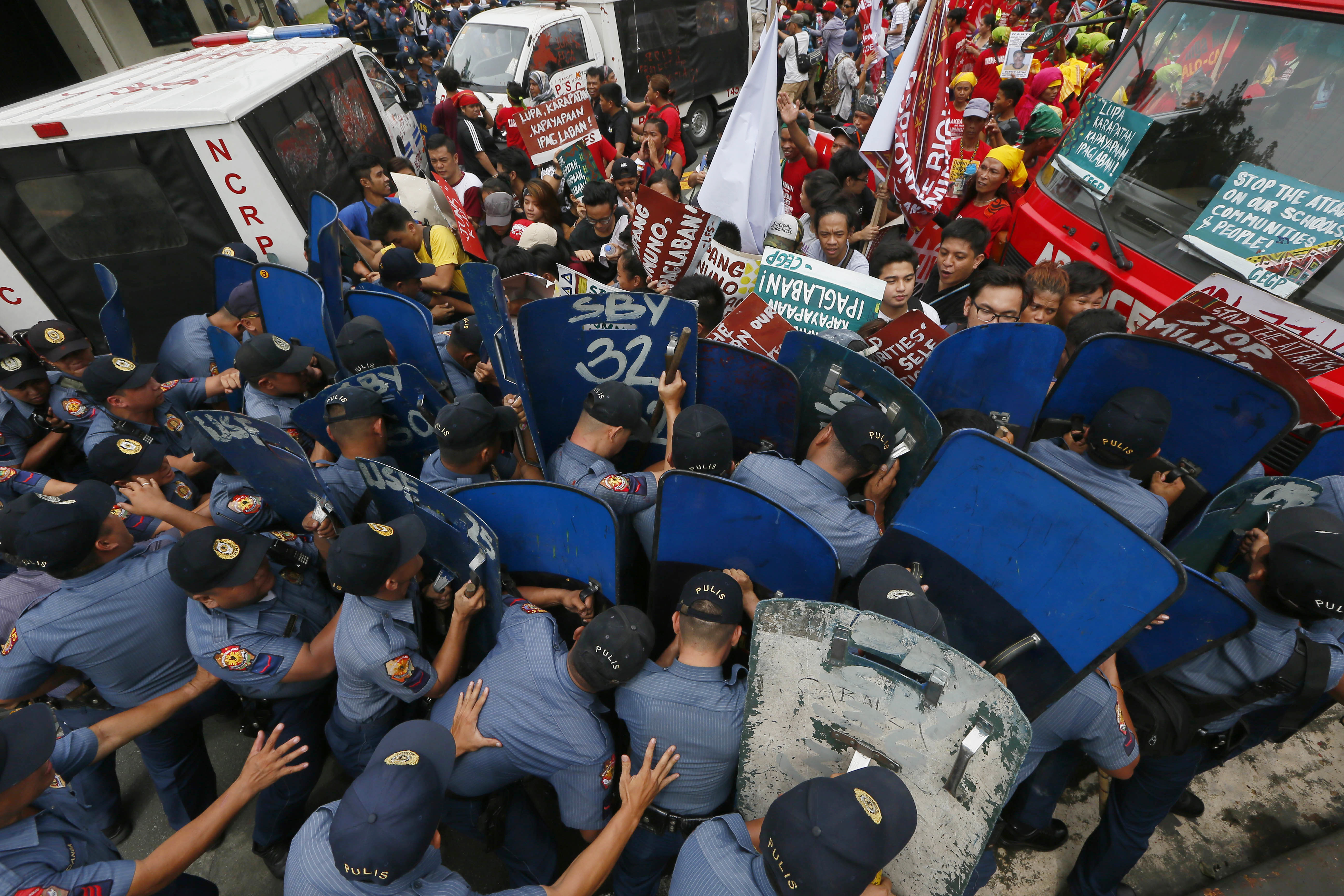 Police and protesters clash during a violent protest outside the U.S. Embassy in Manila, Philippines Wednesday, Oct. 19, 2016. A Philippine police van rammed into protesters, leaving several bloodied, as an anti-U.S. rally turned violent Wednesday at the American Embassy in Manila. (AP Photo/Bullit Marquez)