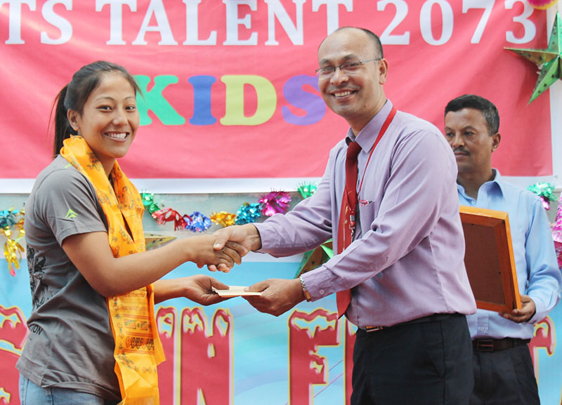 Hill Town School Principal Rajan Tandukar felicitating the 12th SAG gold medallist Phupu Lhamu Khatri in Kathmandu on Friday, October 7, 2016. Photo: THT