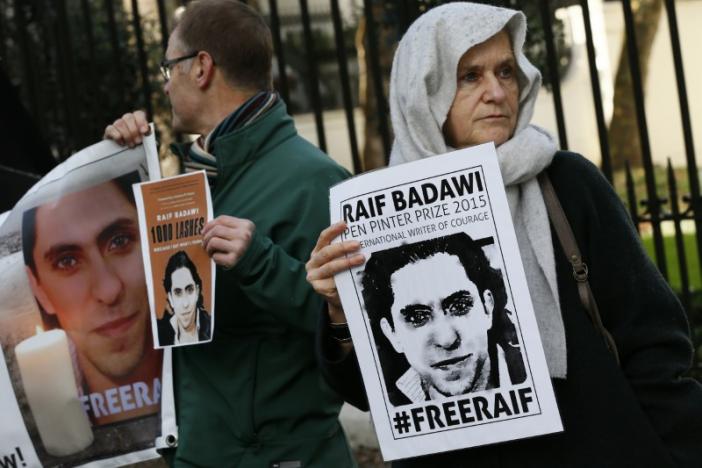 Demonstrators hold placards during a protest for Saudi blogger Raif Badawi, outside the Saudi Arabian Embassy in London, Britain January 8, 2016.   REUTERS/Stefan Wermuth