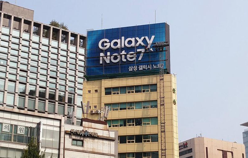 Workers take a billboard of Samsung Electronics' Galaxy Note 7 off from atop a building in central Seoul, South Korea, October 14, 2016. REUTERS/Staff