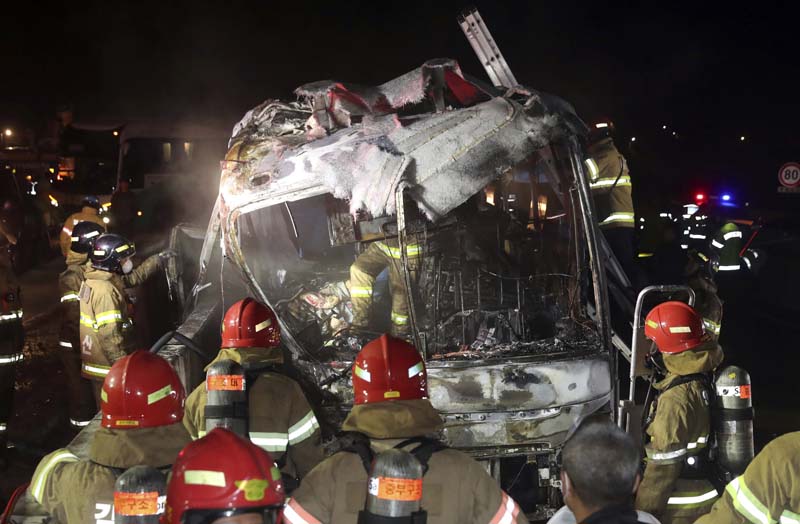 South Korean firefighters check a burned out bus on the Gyeongbu Expressway near the southeastern city of Ulsan, South Korea, on Friday, October 14, 2016. Photo: AP