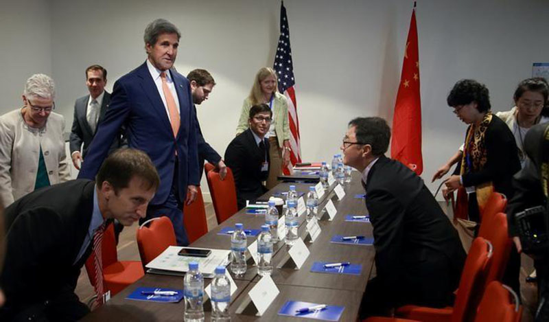 US Secretary of State John Kerry (in red neck tie) takes his seat during a bilateral meeting with Chinese Deputy Minister For Environment Protection Zhai Qing to promote US climate and environmental goals, at the Meeting of the Parties to the Montreal Protocol on the elimination of hydro fluorocarbons (HFCs) use in Rwanda's capital Kigali, on October 14, 2016. Photo: Reuters