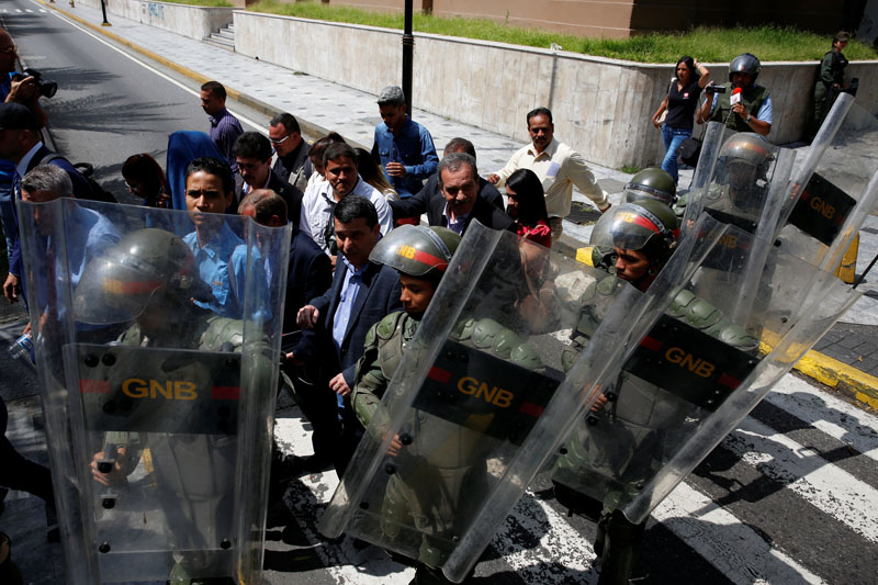 Venezuelan National Guards escort deputies and people as they walk out from the National Assembly after a session in Caracas, Venezuela, on October 27, 2016. Photo: Reuters