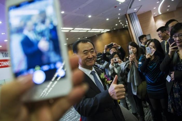 Wang Jianlin (C), chairman of Wanda commercial properties, flashes a thumbs up during the debut of the company at the Hong Kong Stock Exchange December 23,2014.  REUTERS/Tyrone Siu/Files
