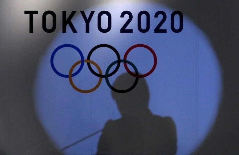 A shadow of of Tokyo governor Yuriko Koike is seen on the logo of Tokyo 2020 Olympic games during the Olympic and Paralympic flag-raising ceremony at Tokyo Metropolitan Government Building in Tokyo, Japan, September 21, 2016.  REUTERS/Toru Hanai/Files