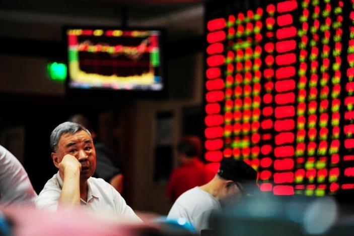 An investor sits in front of an electronic board showing stock information at a brokerage house in Nanjing, Jiangsu province, China, September 27, 2016. REUTERS/Stringer