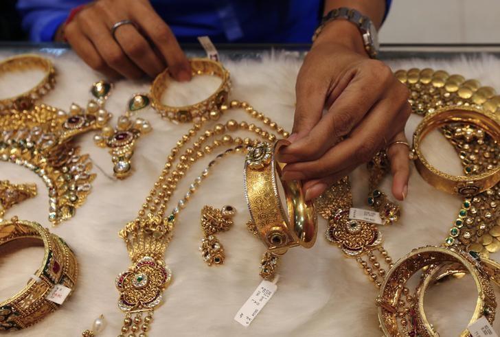 A woman looks at a gold bangle inside a jewellery showroom at a market in Mumbai January 15, 2015.  REUTERS/Shailesh Andrade