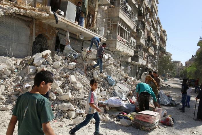 People remove belongings from a damaged site after an air strike Sunday in the rebel-held besieged al-Qaterji neighbourhood of Aleppo, Syria. REUTERS/Abdalrhman Ismail