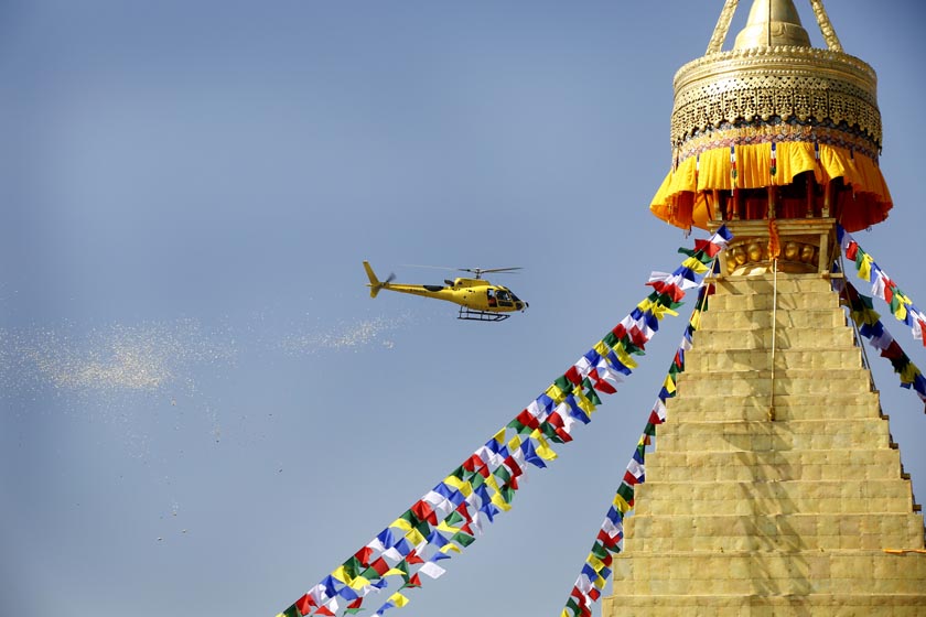 A helicopter flies above the ancient Bouddhanath Stupa to release flowers while rituals are being carried out for the purification of the recently renovated Bouddhanath Stupa. Photo: Rajesh Gurung