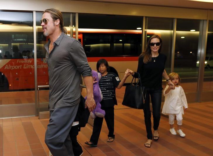 Hollywood actors Brad Pitt (L) and actress Angelina Jolie (2nd R) arrive with their children Knox (beside Pitt), Vivienne (R) and Pax (C) at Haneda international airport in Tokyo, Japan on July 28, 2013.  REUTERS/Issei Kato/File Photo