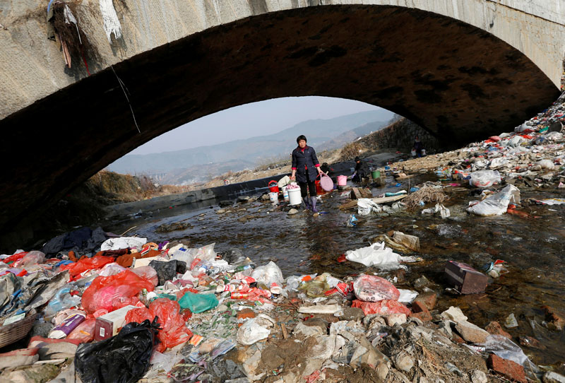 File - Villagers wash clothes in the garbage-filled Shenling River, in Yuexi county, Anhui province, China on February 14, 2015. Photo: Reuters