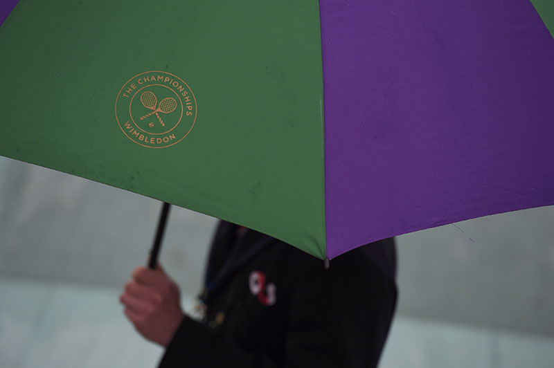 File- Employee holds an umbrella as rain delays play at All England Lawn Tennis &amp; Croquet Club in Wimbledon, England on June 29, 2016 Photo: REUTERS
