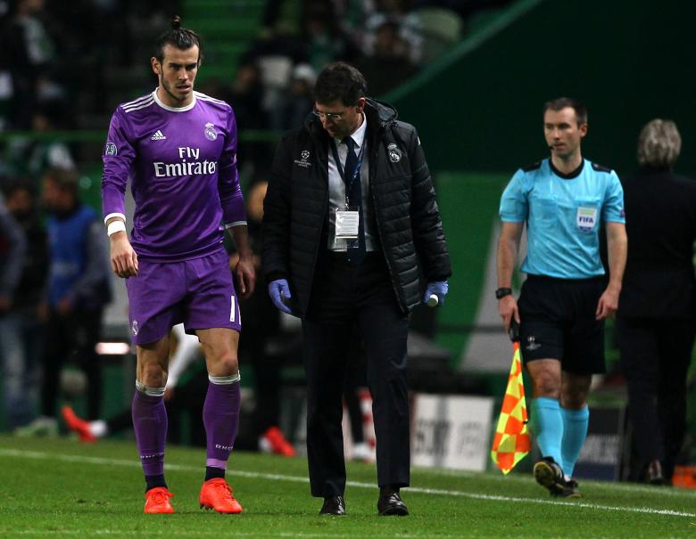 Real Madrid's Gareth Bale walks on the pitch observed by a team doctor after sustaining an ankle injury during their Champions League match against Sporting in Lisbon, Portugal, November 22, 2016. Picture taken November 22, 2016.  REUTERS/Pedro Nunes