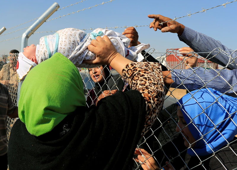 People see their relatives who had fled from Mosul at a fence surrounding Al-Khazer refugee camp, east of Mosul, Iraq, on November 4, 2016.  Photo: Reuters