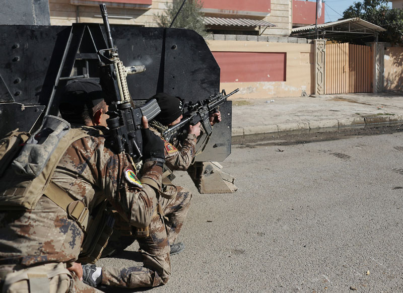 An Iraqi special forces soldier fires his rifle after an Islamic State suicide car bomb attack against Iraqi special forces during clashes in Mosul, Iraq, on  November 19, 2016. Photo: Reuters